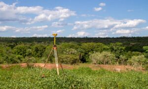 topographic survey equipment terrain mapping - ALTA SURVEY Tampa GNSS tripod set up in a rural landscape for a topographic survey, capturing land elevation and natural terrain features for construction planning.