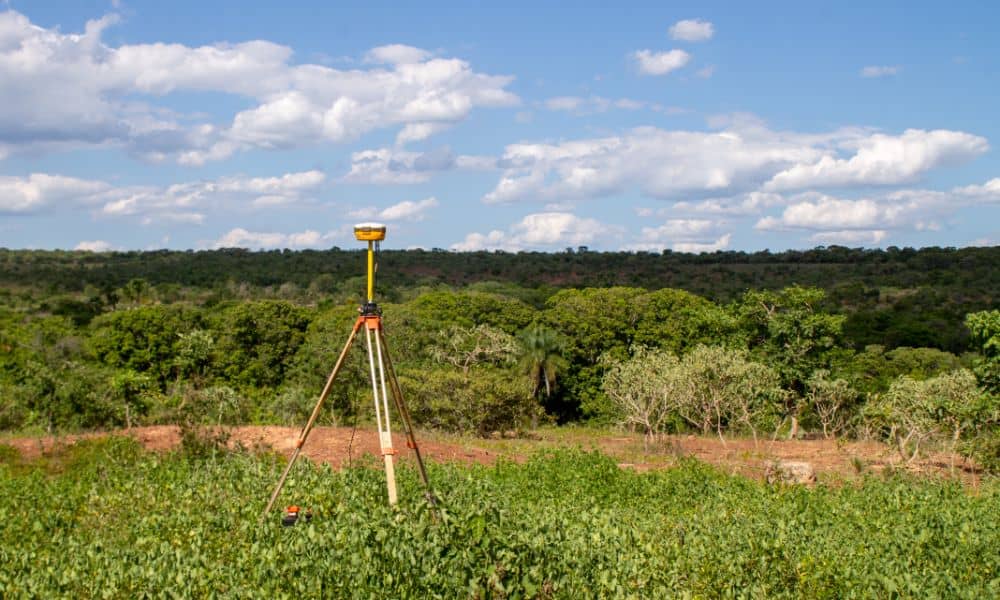 topographic survey equipment terrain mapping - ALTA SURVEY Tampa GNSS tripod set up in a rural landscape for a topographic survey, capturing land elevation and natural terrain features for construction planning.
