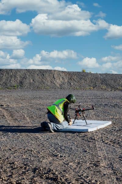 Licensed surveyor preparing a drone for aerial land mapping and boundary verification