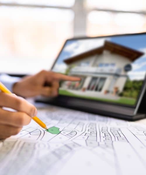 Surveyor reviewing site maps and property plans to assess land history and identify issues during a due diligence survey