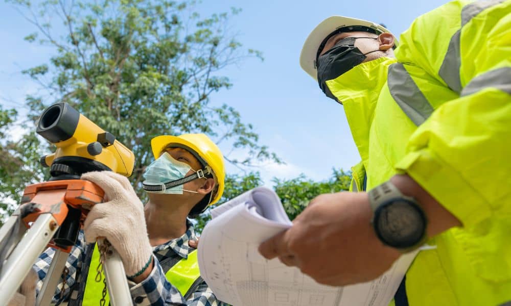 Surveyors reviewing site plan field - ALTA SURVEY Tampa Surveyors reviewing site plans before fieldwork to determine land survey cost