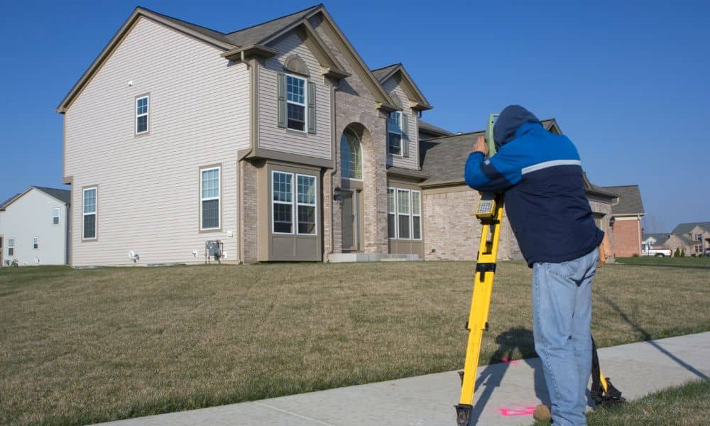 Land surveying in a residential area to check driveway placement and property boundaries